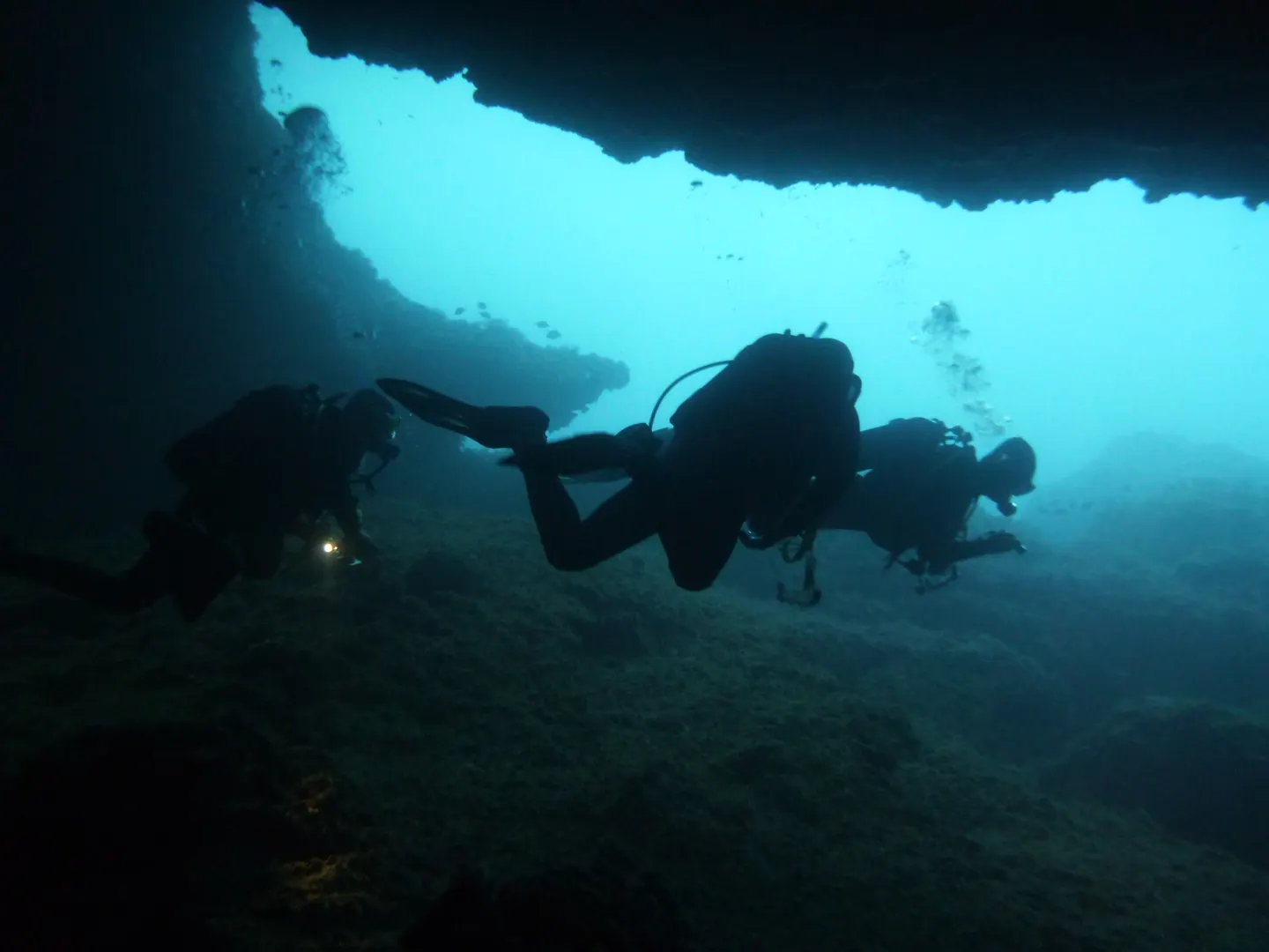 Divers exiting an underwater cavern